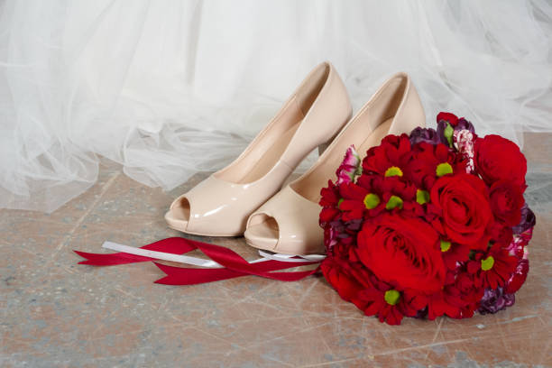 istock Red the bride's bouquet and white shoes 1202320814
