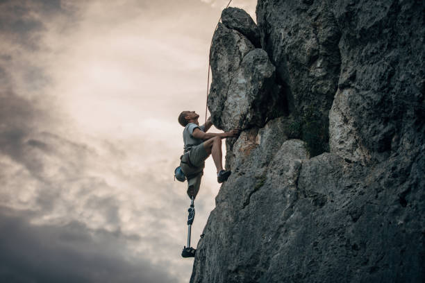 Disability man free rock climbing Man with prosthetic leg free mountain climbing athlete with disabilities photos stock pictures, royalty-free photos & images