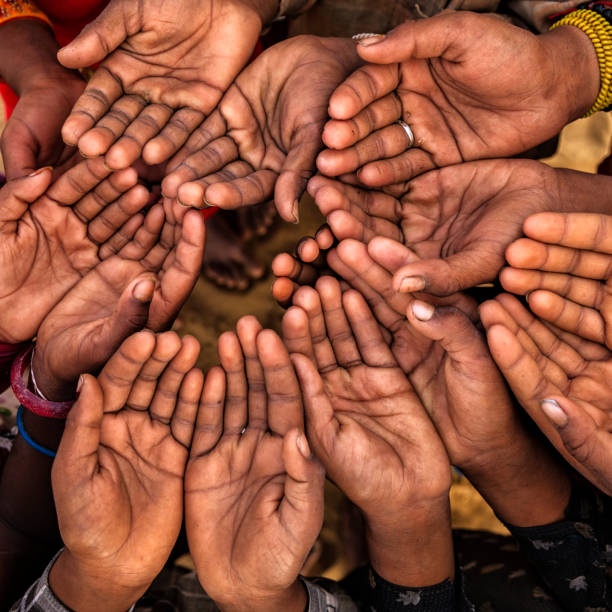 istock Hands of poor - children asking for help, India 1202328192