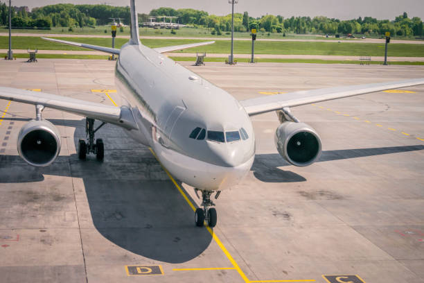 un gran avión de pasajeros se encuentra en el aeródromo, vista frontal de la cabina. el avión está estacionado cerca de la terminal. el avión aterrizó en la pista y se está preparando para descargar el equipaje. - landed airplane travel commercial airplane fotografías e imágenes de stock