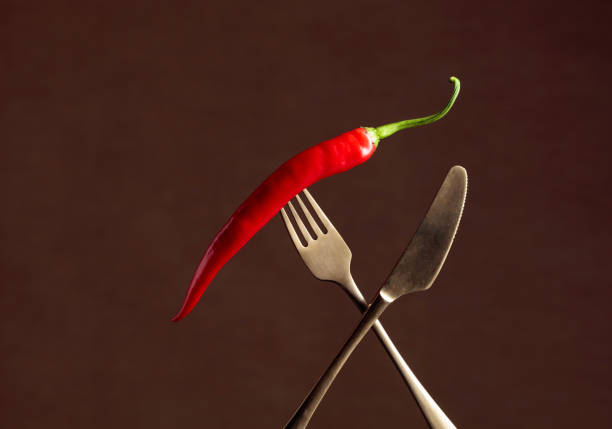 Hot chili red pepper on a fork. Spice concept. Copy space.