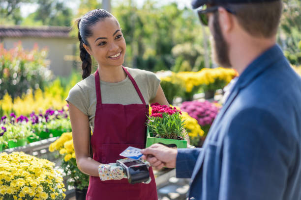 istock Man paying on POS terminal at the greenhouse 1202331042