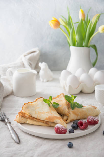 Tasty traditional russian pancakes with blueberry. Regional food. Traditional russian blini with blueberry and raspberries on white. Pancake week. Shrovetide. Regional food. Close up. Vertical format. Spring. bunny pancake stock pictures, royalty-free photos & images