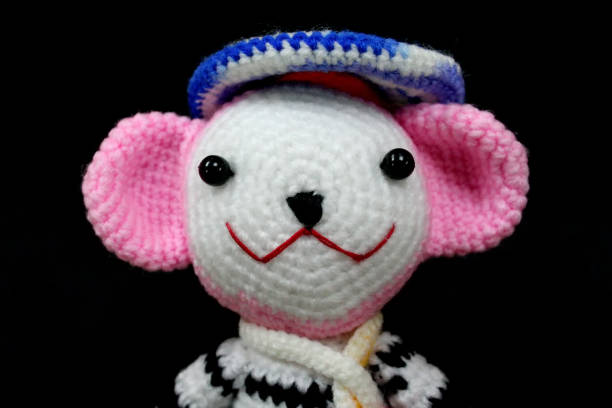 istock crochet yarn doll pink and white on black background 1202331891