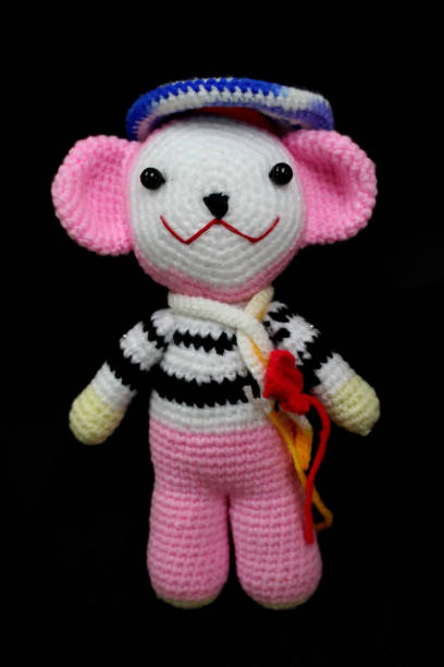 istock crochet yarn doll pink and white on black background 1202331897