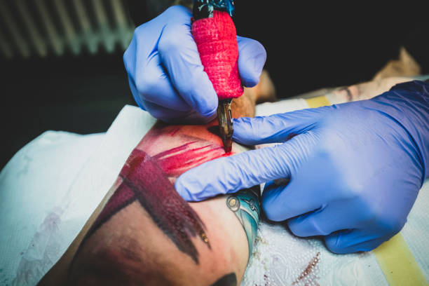 istock Tattoo artist coloring a tattoo 1202331962