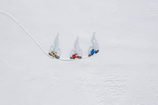 zdjęcie z lotu ptaka z drona grupy przyjaciół jeżdżących na grubym rowerze w śniegu w ontario, kanada - transportation mountain winter couple zdjęcia i obrazy z banku zdjęć