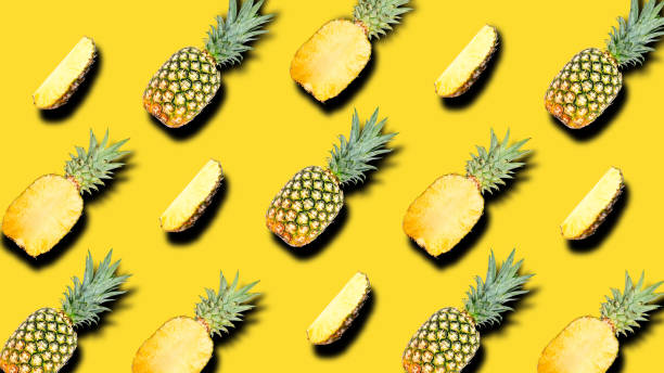 istock Creative pattern of fruit whole and slice pineapples with shadows on a bright yellow summer background. Clipping Path. 1202333689