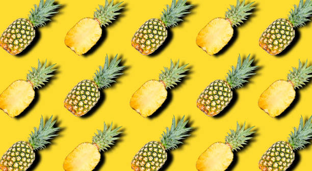 istock Creative pattern of fruit whole and slice pineapples with shadows on a bright yellow summer background. Clipping Path. 1202333870