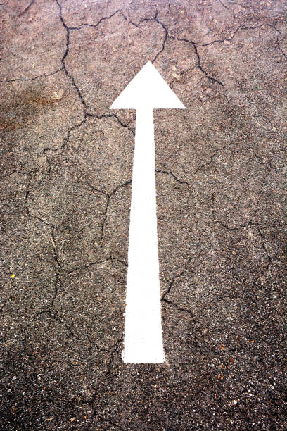 istock white arrow sign on the dry soil, ground, background 1202337522