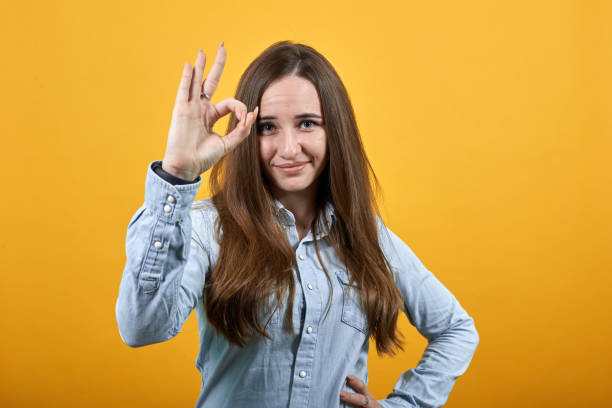 istock Cheerful charming caucasian woman in studio doing okay gesture, smiling. 1202340326