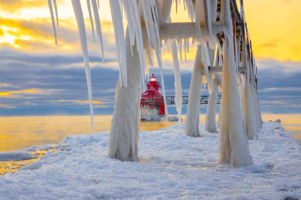 istock Winter ice buildup on scenic pier and lighthouse. 1202340479