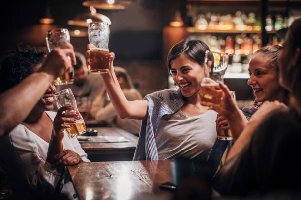 istock Friends having fun drinking beer in a bar 1202341679