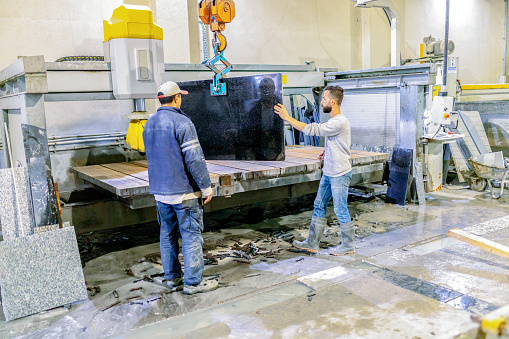 Marble factory workers with crane