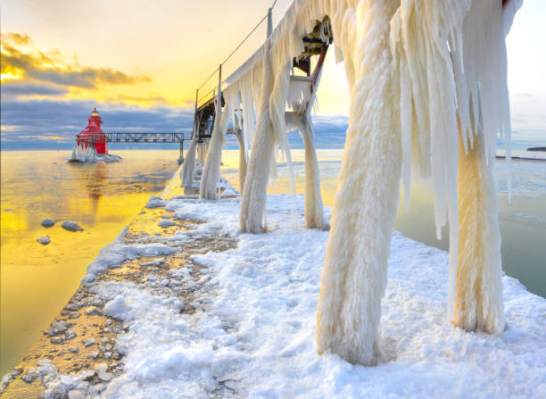 istock Winter ice buildup on scenic pier and lighthouse. 1202341991