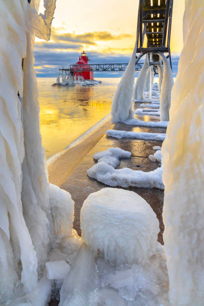 istock Winter ice buildup on scenic pier and lighthouse. 1202341998