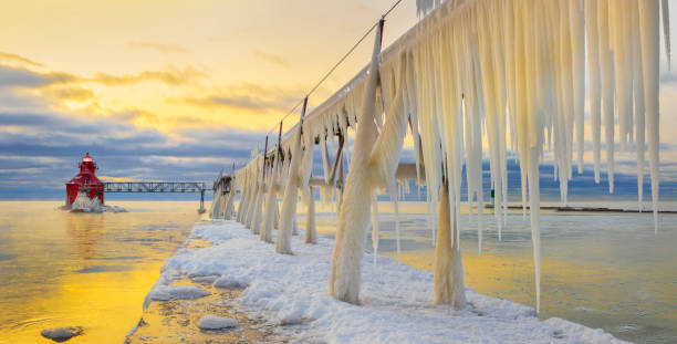 istock Winter ice buildup on scenic pier and lighthouse. 1202342114