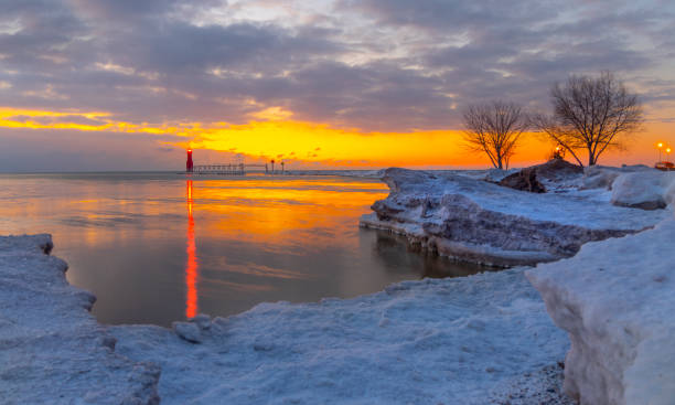 istock Red lighthouse beacon reflects off thin ice on cold still lake. 1202342548