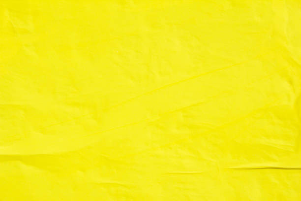 Yellow crumpled poster on billboard. Yellow paper placard texture background.