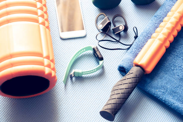 equipamentos fitness e eletrônicos em um tapete azul de yoga - foto de acervo