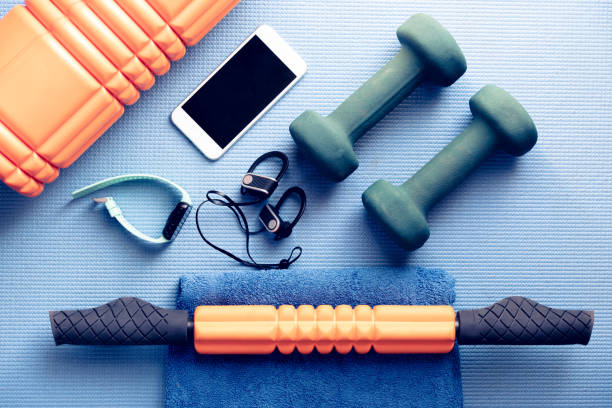 equipos de fitness y electrónica en una estera de yoga azul - foto de stock