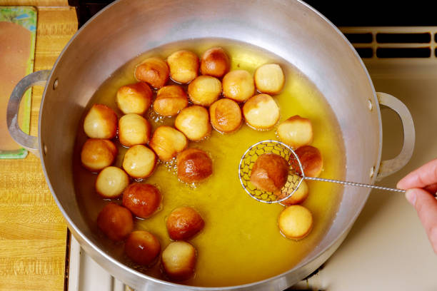 istock Munchkins frying in hot oil in deep pan. 1202346014