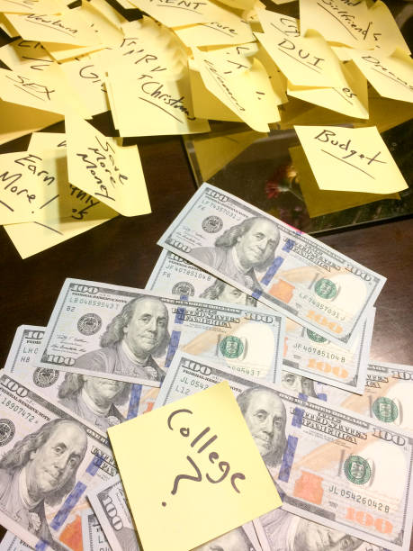 istock Yellow post it notes on table with pile of american cash 1202346678