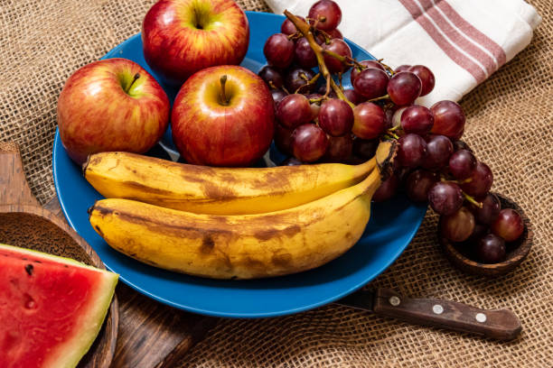 istock assorted fresh fruits on plate on wooden table 1202347422