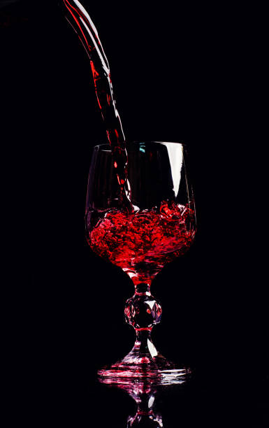 istock Red wine pouring into wine glass 1202348155