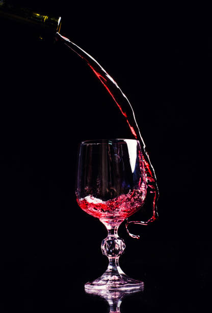 istock Red wine pouring into wine glass 1202348178