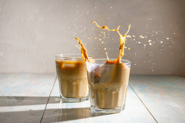 Splash in iced coffee on wooden background
