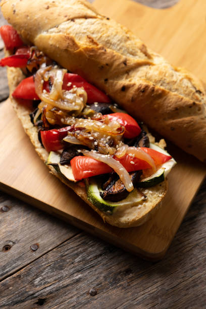 istock Vegan sub sandwich with grilled vegetables on wooden background 1202351364