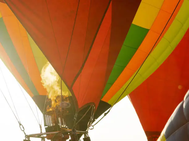 Fire warms the air in a balloon. Balloonists prepare the balloons for flight. Festival of aeronautics