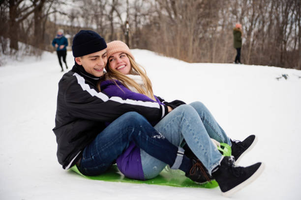 istock Generation Z couple ready to slide down in snowy public park. 1202352759