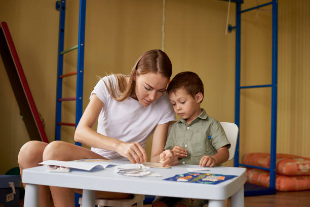 istock Mother and son draw at a table inside the room. 1202354663