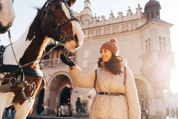 Photo of Young woman and horses at Main Square in Krakow, Poland