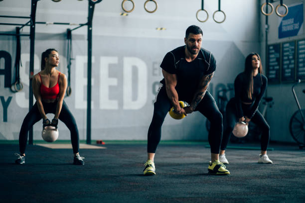 istock Three friends pushing themselves to the limit in a gym 1202356073