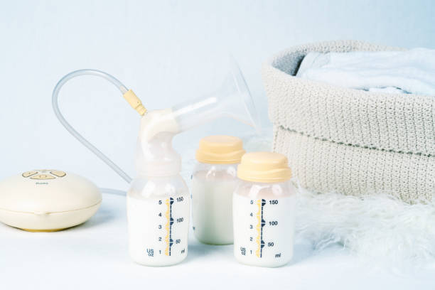 Medical electric breast pump to increase milk supply for breastfeeding mother and children's clothing Medical electric breast pump to increase milk supply for breastfeeding mother and children's clothing east germany photos stock pictures, royalty-free photos & images