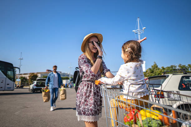 istock Cute daughter doing a high-five with mother while waiting for a father after shopping 1202363560