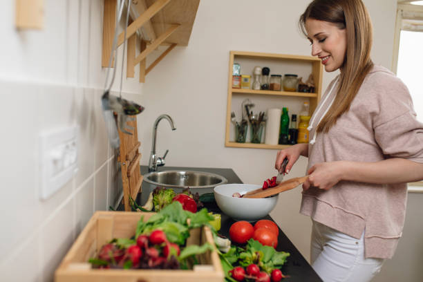 istock Woman Mixing Cut Vegetables 1202377471