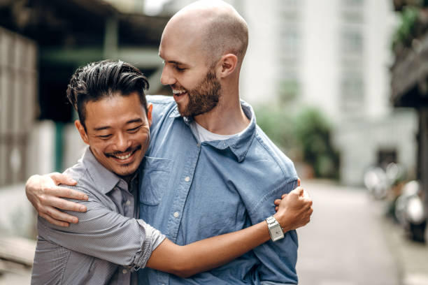 Homosexual couple in city Homosexual couple walking outdoors on city street gay man stock pictures, royalty-free photos & images