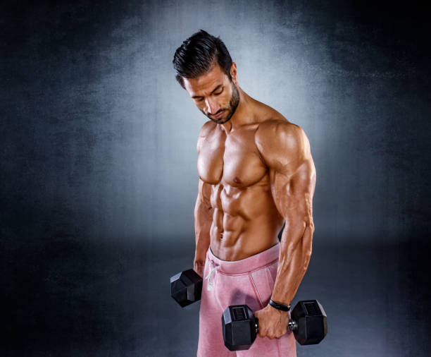 istock Strong Muscular Men Exercise With Weights. Bodybuilder doing dumbbell bicep curls 1202379559