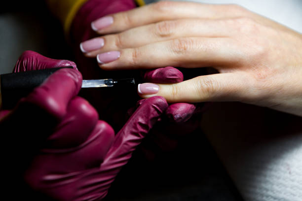 istock Friendly nail technician applying a product on customers hand 1202380703