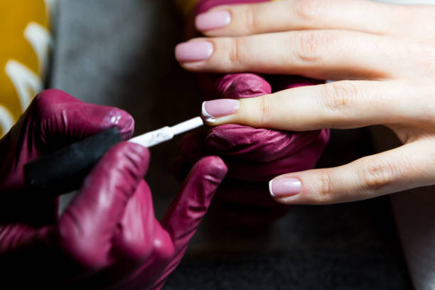 istock Friendly nail technician applying a product on customers hand 1202380704