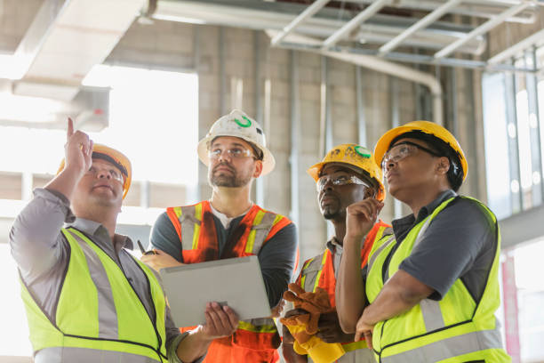 trabajadores de la construcción que se reúnen, con tableta digital - female with group of males fotos fotografías e imágenes de stock