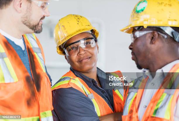 Female Construction Worker With Group Of Coworkers Stock Photo - Download Image Now - Construction Worker, Construction Site, Construction Industry