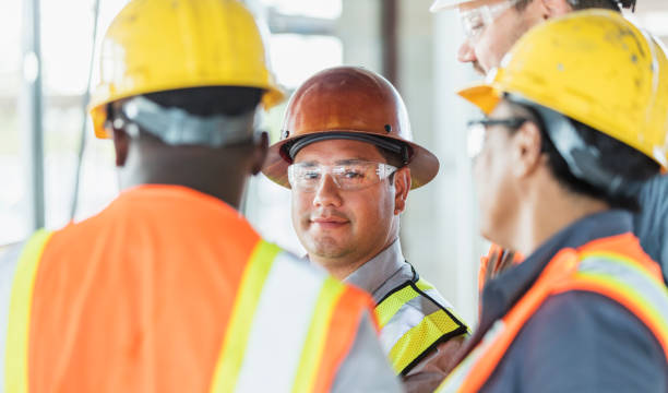 istock Hispanic construction worker with group of coworkers 1202383306