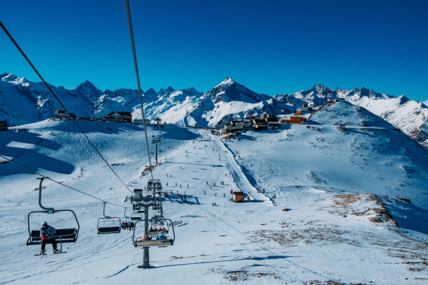 abfahrtskigebiet in den hohen bergen. skipiste und seilbahn - ski skiing european alps resting stock-fotos und bilder