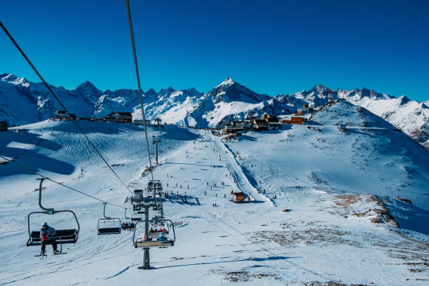 istock Downhill skiing resort in high mountains. Ski slope and ropeway lift 1202383438