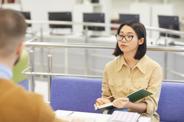 istock Young Asian Woman in Library 1202384371